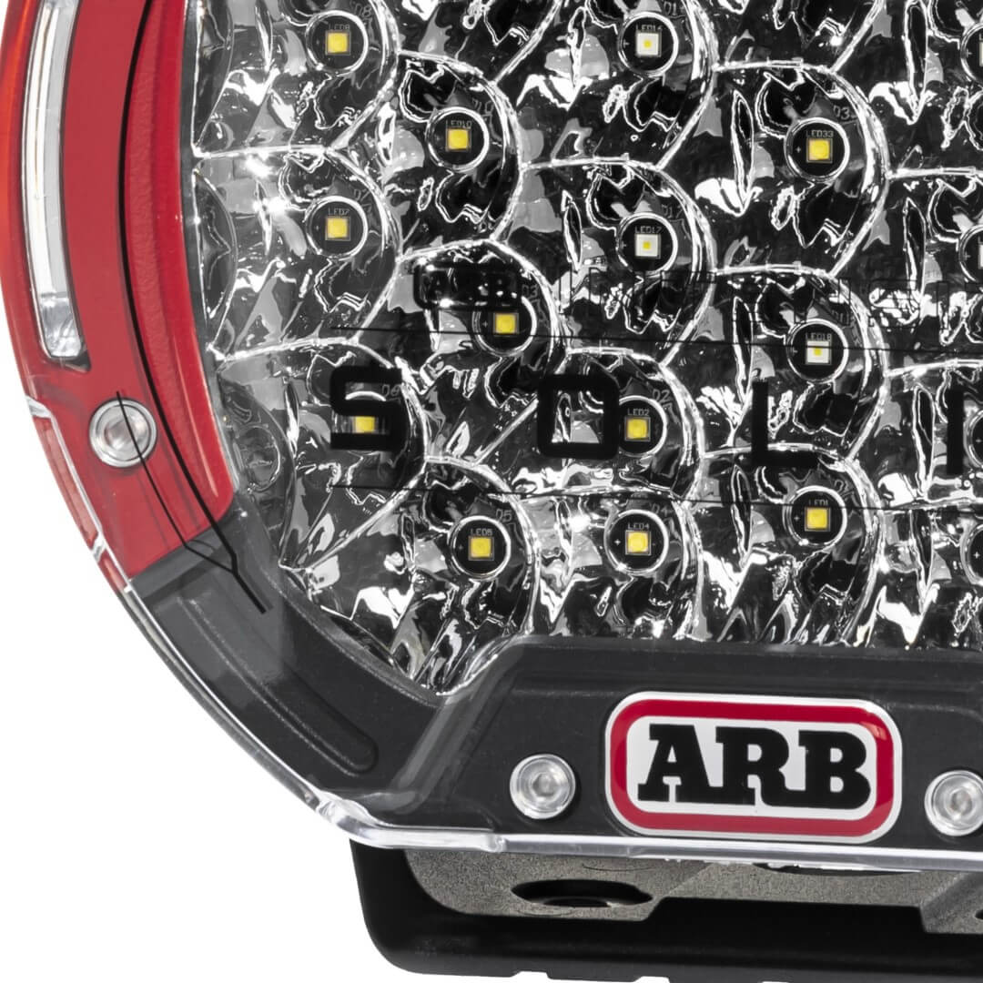 ARB Intensity Solis 36 Flood Driving Light close up showcasing red bezels and high performance LEDs. ARB Logo shown and the bottom of the driving light
