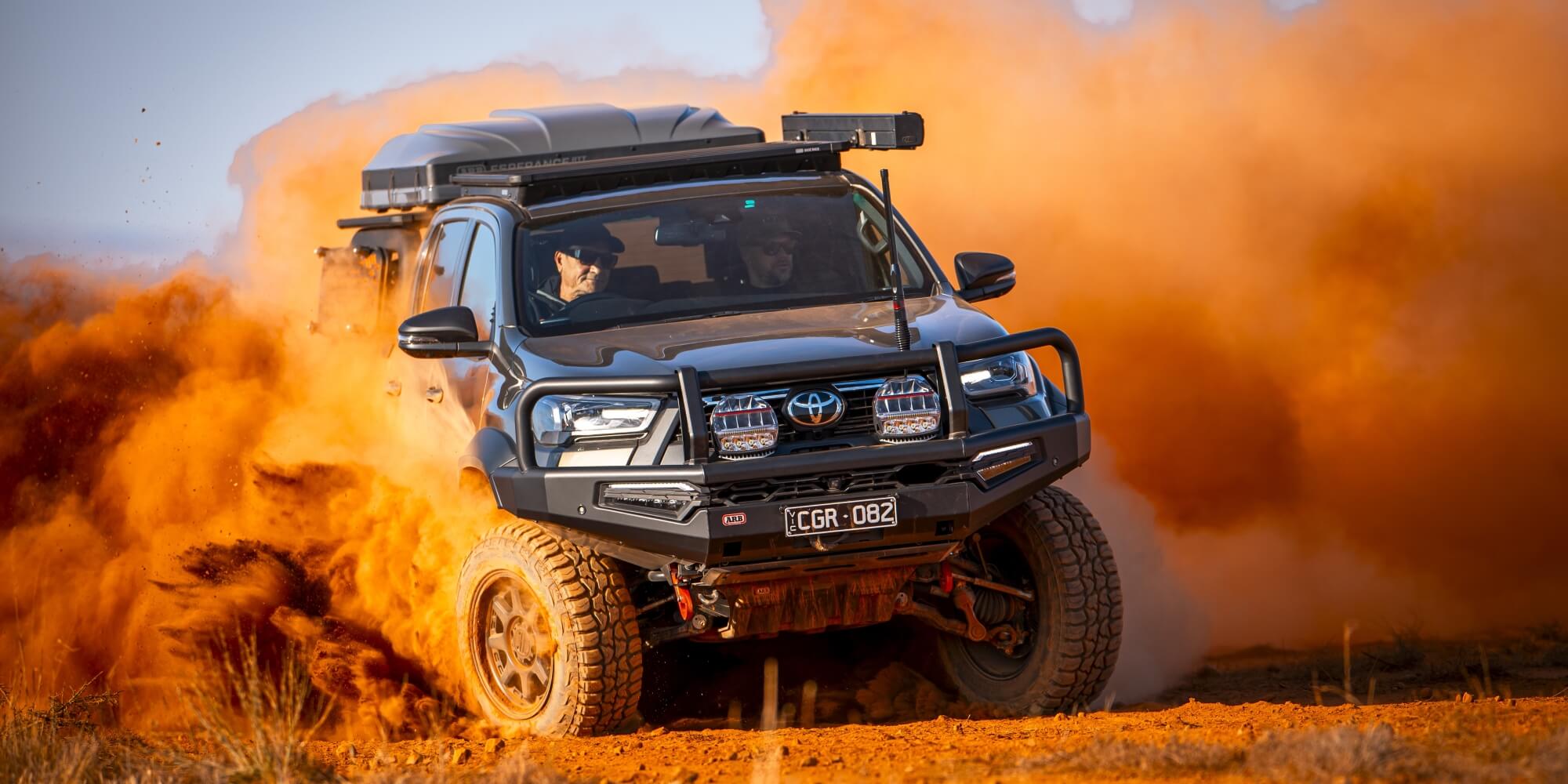 ARB Toyota Hilux drifting in red dusty terrain showing Intensity IQ driving lights mounted on top of Black Summit MKII Bull Bar